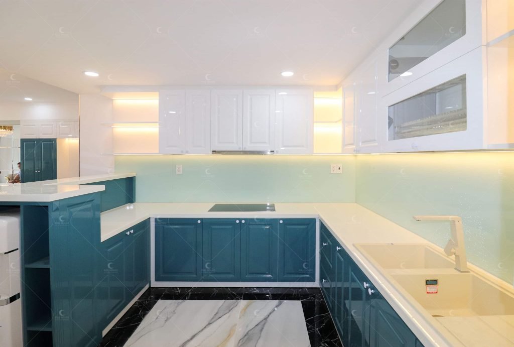 Không gian bếp sang trọng với hệ tủ màu xanh teal và trắng